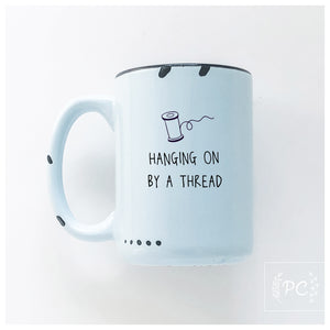 hanging on by a thread | ceramic mug