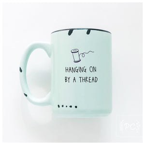 hanging on by a thread | ceramic mug