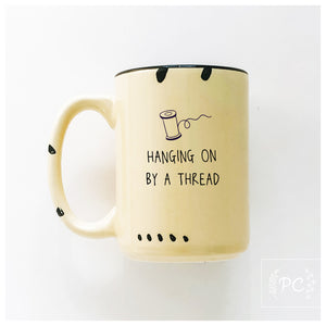 hanging on by a thread | ceramic mug